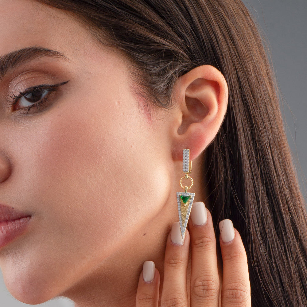 Close-up of a woman wearing a gold and green triangle earring.