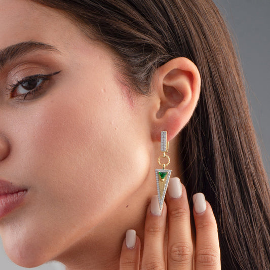 Close-up of a woman wearing a gold and green triangle earring.